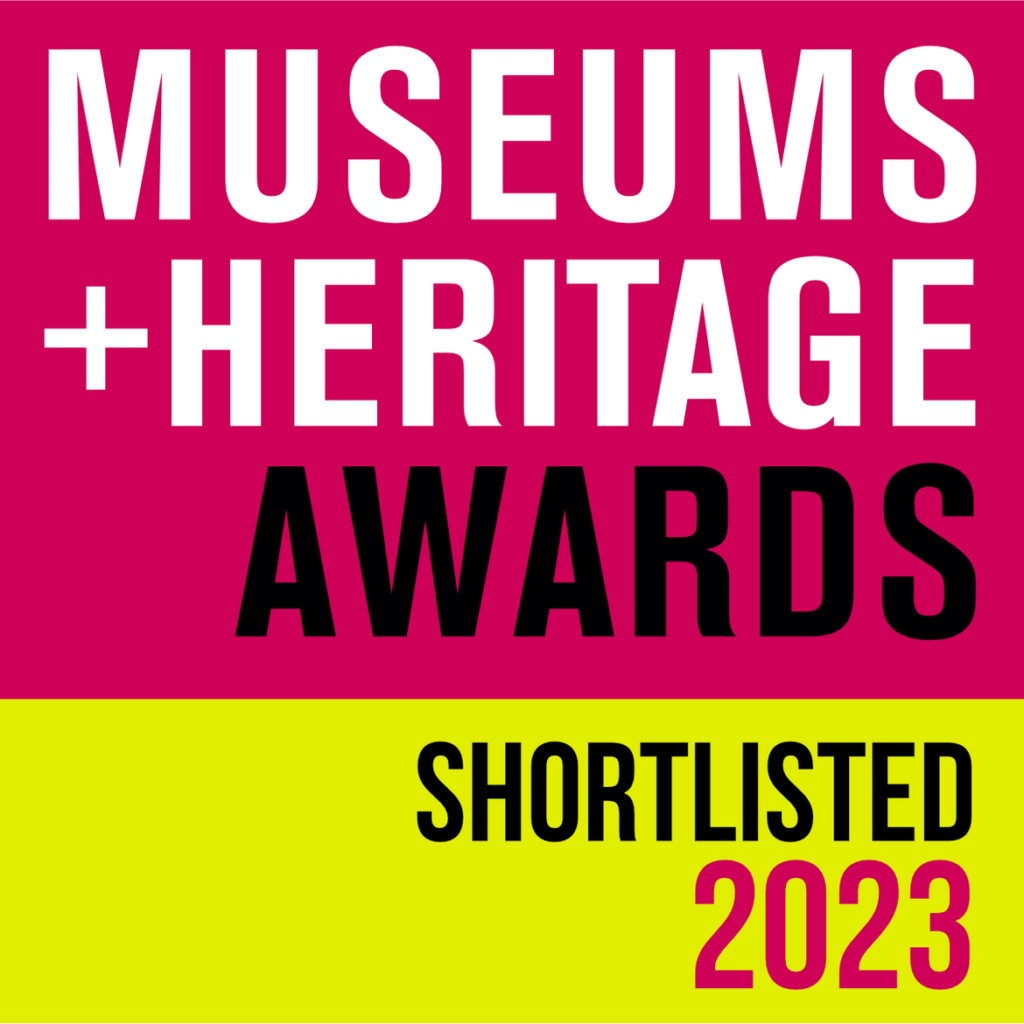Square logo with top area in bright pink  background and bottom area in yellow. Text in mix of white, black and pink font reading "Museums and Heritage Awards shortlisted 2023"